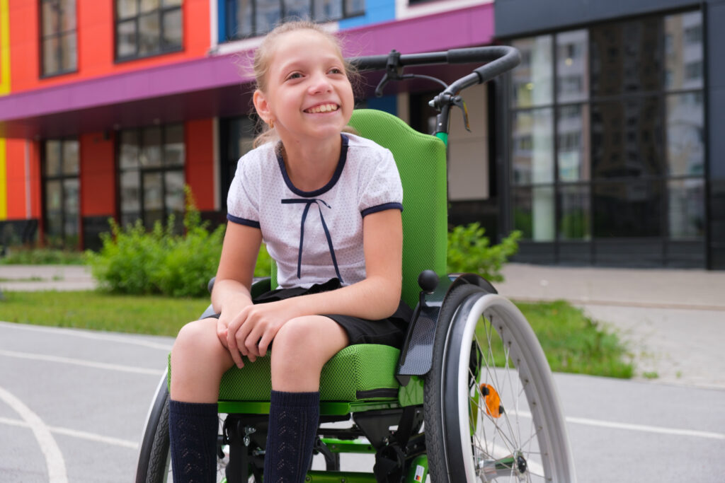 Special child on wheelchair. Girl in school uniform on the background of the school. Back to school. High quality photo
